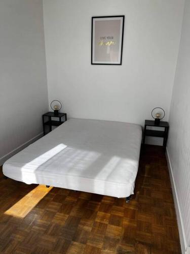 1 cama blanca en una habitación con 2 mesitas de noche en Appartement T2 Chalons, en Châlons-en-Champagne