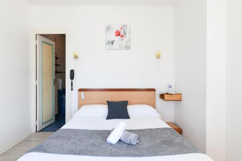 a bedroom with a large white bed with two pillows at Logis Hôtel La crémaillère in Hagetmau