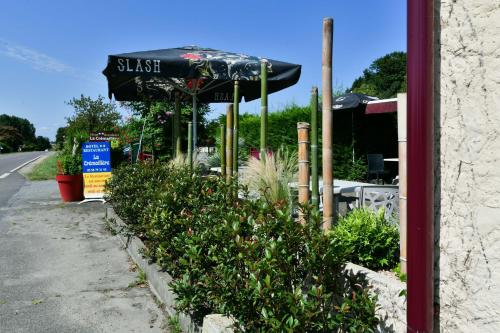 a restaurant with an umbrella on the side of the street at Logis Hôtel La crémaillère in Hagetmau