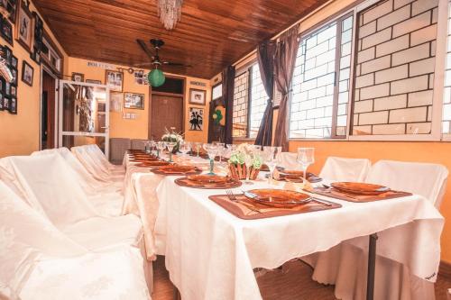 a long table with white tables and white chairs at Jesiwa B's Little Palace in Accra