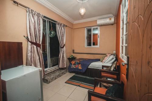 a small bedroom with a bed and a window at Jesiwa B's Little Palace in Accra