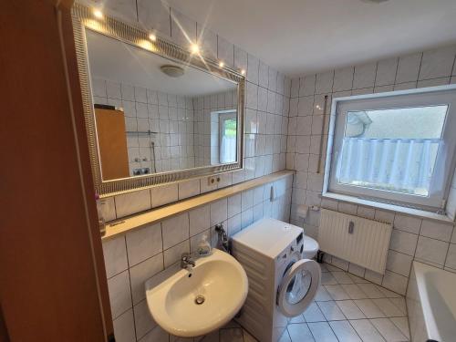 uma casa de banho com um lavatório, um WC e um espelho. em Ferienwohnung Unterneukirchen mit Garten-Terrasse em Unterneukirchen