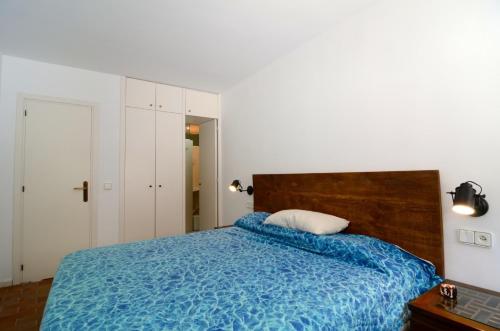 een slaapkamer met een bed met een blauwe deken bij Escorpora in L'Estartit