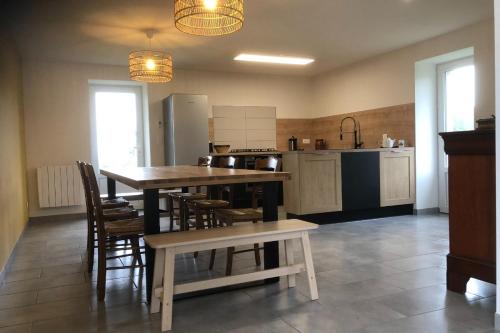 une cuisine avec une table et des chaises dans une pièce dans l'établissement Etape de Bel Air, à Droiturier