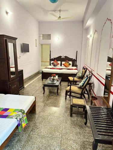 a room with two beds and a couch and a table at Rawla Mrignayani Palace in Jaipur