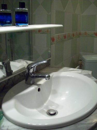 - un lavabo blanc avec un robinet en chrome dans l'établissement LA CORSE la montagne, les plages, les iles, à Monticello