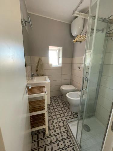 a bathroom with a toilet and a sink and a shower at Casa Marina in Scilla