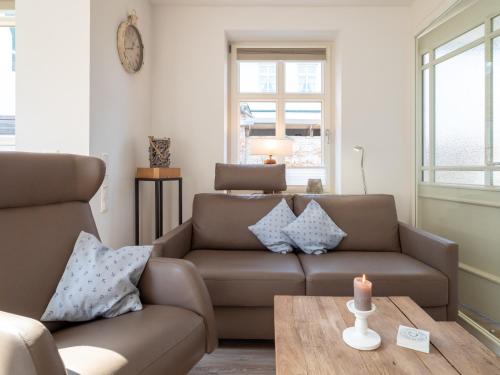 a living room with a couch and a table with a candle at Inselsünn Hotel und Apartments in Spiekeroog
