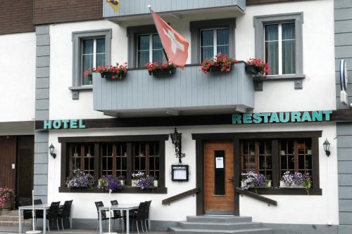 a hotel with a flag on the front of it at Hotel Tourist in Meiringen