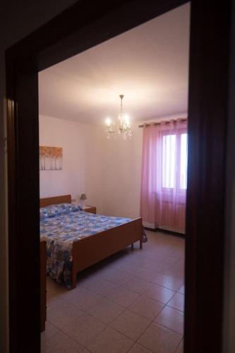 1 dormitorio con cama y lámpara de araña en Nel tranquillo centro d'Isola en Isola di Fano