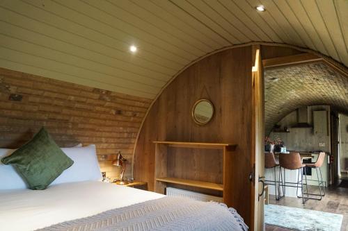 a bedroom with a bed in a wooden room at Hares View in Rhayader