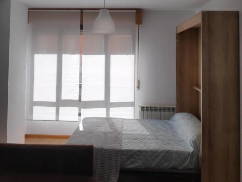 a bedroom with a bed and a large window at Estudio Francés, Parking privado gratuito in Logroño