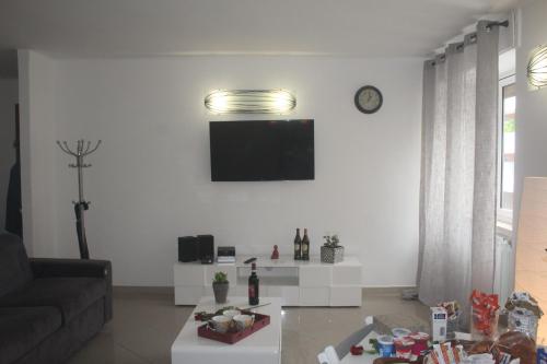a living room with a couch and a tv on a wall at Rosabella Casa Vacanze in Bari