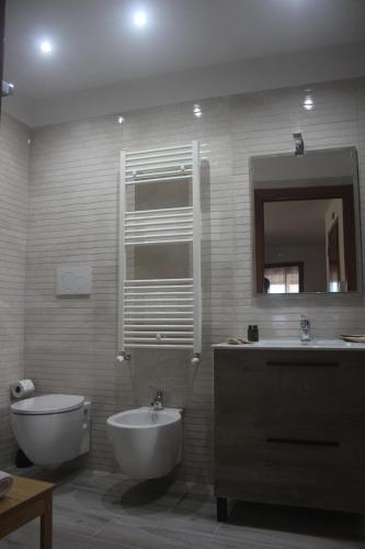 a bathroom with a sink and a toilet and a mirror at Rosabella Casa Vacanze in Bari