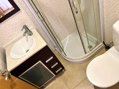 uma casa de banho com um lavatório, um chuveiro e um WC. em Apartamentos Deluxe Marina Dor em Oropesa del Mar