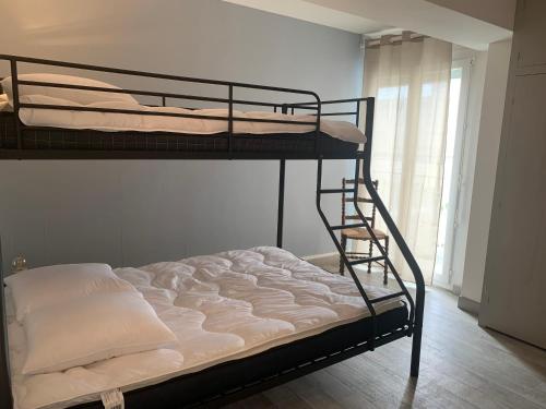 1 Schlafzimmer mit 2 Etagenbetten und einem Fenster in der Unterkunft Arcadia appart face mer 7 pers in Le Touquet-Paris-Plage