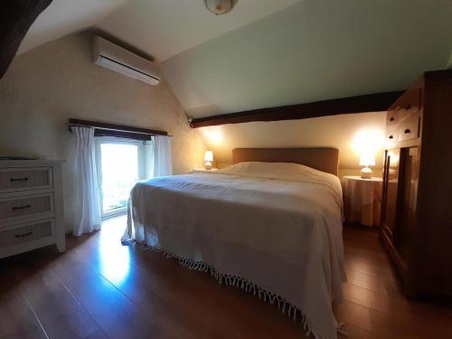 a bedroom with a large bed and a window at Gte Avec Piscine Sainte Anne in Ygrande