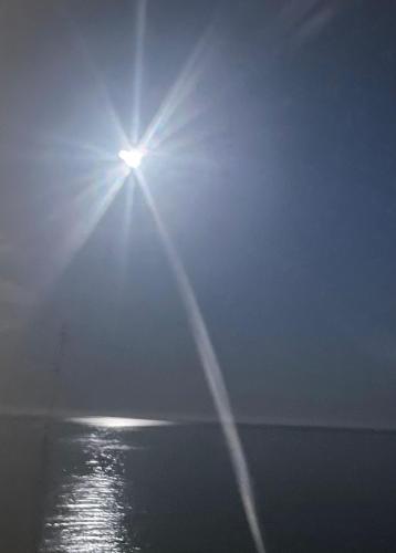 a sun shining in the sky over the water at Tahiti Dreams in El Campello