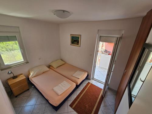 - une petite chambre avec 2 lits et une fenêtre dans l'établissement Apartments Ani, à Žaborić