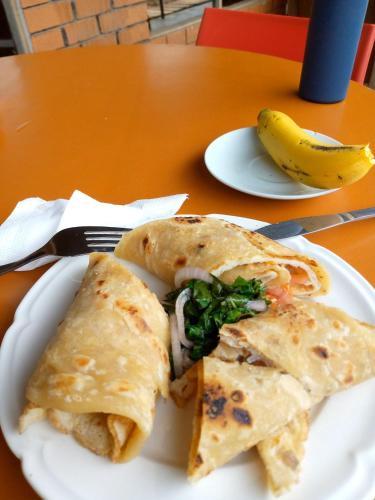 a plate with a sandwich and a banana on a table at Santaviva Hotel in Kisoro