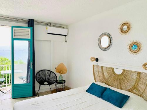 1 dormitorio con cama, espejo y ventana en Studio Bod’Lanmè - Trois îlets, en Les Trois-Îlets