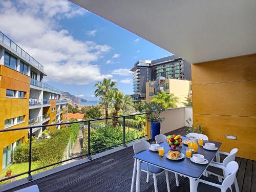 a blue table and chairs on a balcony with a view at The Bay View - by LovelyStay in Funchal