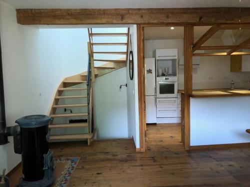 une chambre avec un escalier et une cuisine équipée d'un réfrigérateur. dans l'établissement La Maison au Tilleul, à Tautavel