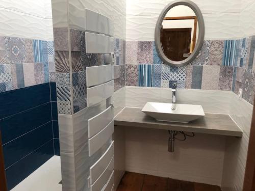 une salle de bain avec un lavabo et un miroir dans l'établissement La Maison au Tilleul, à Tautavel