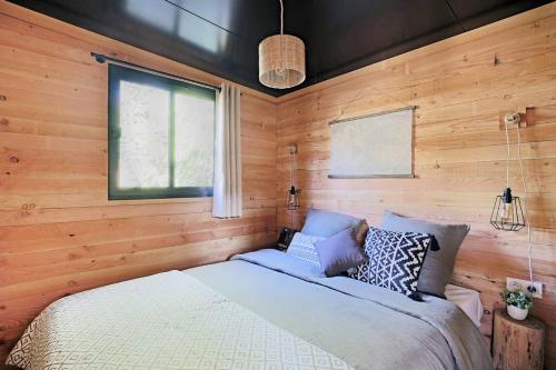 1 dormitorio con 1 cama en una pared de madera en CityKamp Valkenburg - Maastricht en Valkenburg
