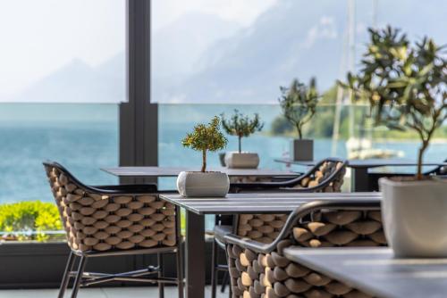 a restaurant with tables and chairs with potted trees on them at Hotel Val Di Sogno - Adults Only in Malcesine