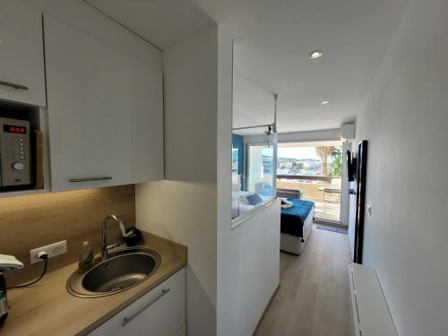 une cuisine avec un évier et une chambre avec un lit dans l'établissement Studio Blue Marina Luxe - Port Nature - Village Naturiste, au Cap d'Agde