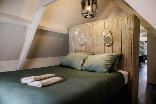 een slaapkamer met een bed met een houten hoofdeinde bij Appartement ‘t-Yesenaertje in Yerseke