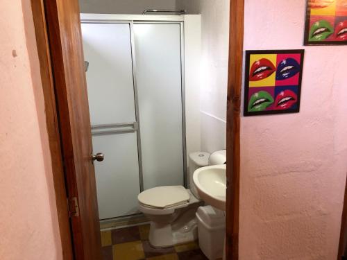 La salle de bains est pourvue de toilettes et d'un lavabo. dans l'établissement apartasuite Centro Historico, à Santa Fe de Antioquia