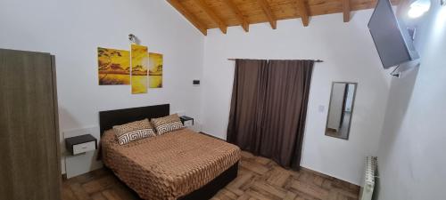 een slaapkamer met een bed en een flatscreen-tv bij Complejo Boulevard Plottier in Plottier