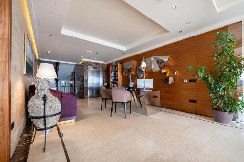 a living room with a table and a dining room at Hotel California by Aycon in Sveti Stefan
