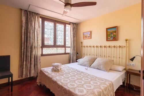 um quarto com uma cama e uma janela em Ático Soho Maria Luisa em Málaga