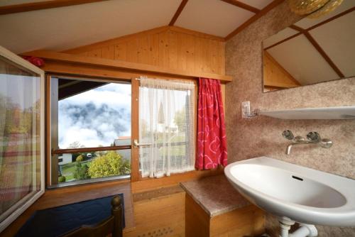 La salle de bains est pourvue d'un lavabo et d'une fenêtre. dans l'établissement Swiss Lodge Hotel Bernerhof, à Wengen