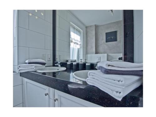 a white bathroom with two sinks and a mirror at Strandbox & Strandresidenz in Norderney