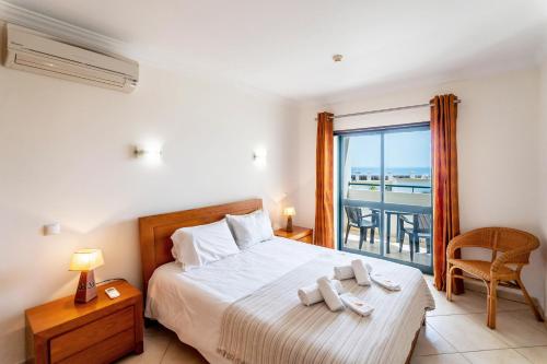 a bedroom with a bed with a view of the ocean at #166 Frat Apartment by Home Holidays in Albufeira