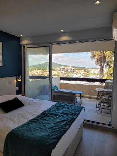 une chambre avec un lit et un balcon avec vue dans l'établissement Studio Blue Marina Luxe - Port Nature - Village Naturiste, au Cap d'Agde