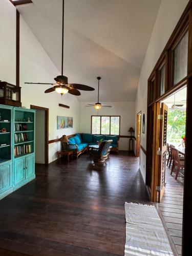 a living room with a blue couch and a ceiling fan at Turtle Beach House in Bocas del Toro