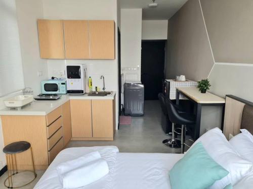 ein Schlafzimmer mit einem Bett und eine Küche mit einem Schreibtisch in der Unterkunft 2R2B Apartment 10 mins to KLCC in Kuala Lumpur