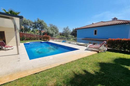 a swimming pool in a yard next to a house at Vila Azul in Amarante