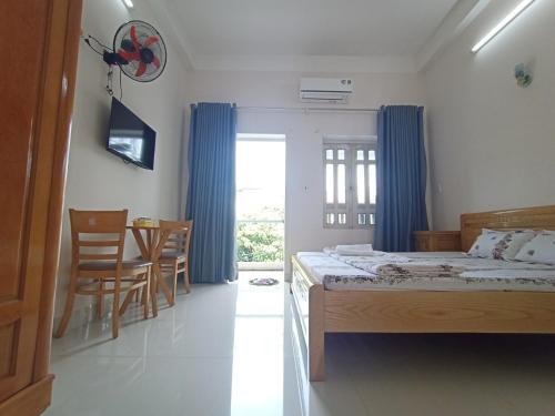 1 dormitorio con 1 cama, mesa y sillas en Nhà nghỉ PHƯƠNG HIỀN, en Vung Tau