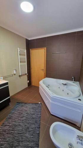 a bathroom with a tub and a toilet and a sink at Vila Azul in Amarante