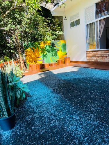 a house with a blue gravel driveway with a mural at Poomaz Peace Palace in Ella
