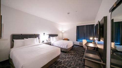 a hotel room with two beds and a television at La Quinta Inn & Suites by Wyndham Austin Parmer Tech Ridge in Austin