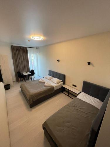 ein Hotelzimmer mit 2 Betten und einem Tisch in der Unterkunft Forsage Hotel in Uschhorod
