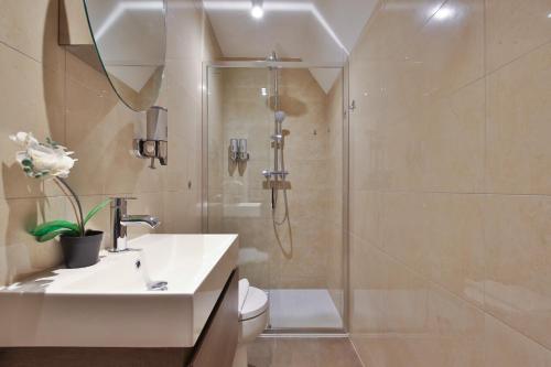 a bathroom with a shower and a sink and a toilet at Imperial Middlesex Street Apartments in London