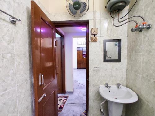 a bathroom with a sink and a mirror and a door at Spacious 3BHK House opp South City Mall in Kolkata